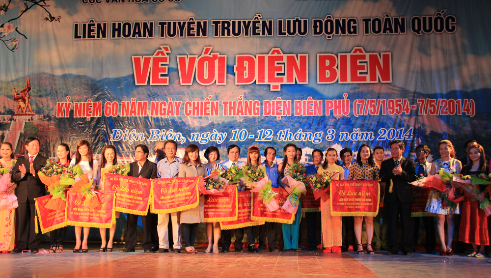 Ban tổ chức trao Cờ lưu niệm và hoa cho các đội tuyên truyền lưu động tham gia Liên hoan. (Ảnh Liên hoan tuyên truyền lưu động toàn quốc năm 2014)