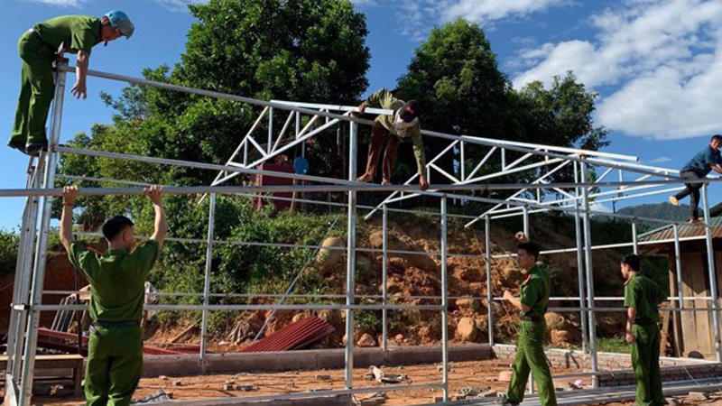 Chiến sĩ Công an huyện Mường Nhé làm nhà cho hộ nghèo đang ở nhà tạm, nhà dột nát tại bản Huổi Hốc, xã Nậm Kè.